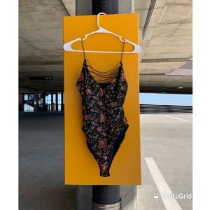 Bright floral onesie, laced front, skinny strap, and tight fitted.